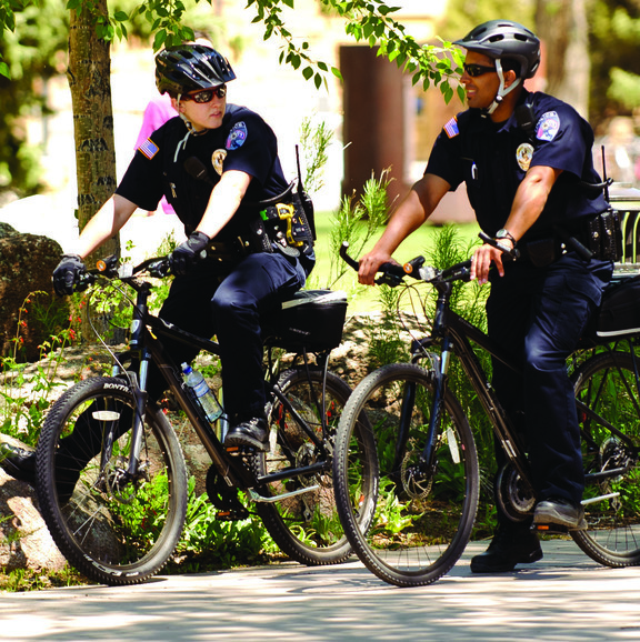 Two university police officers on bikes.