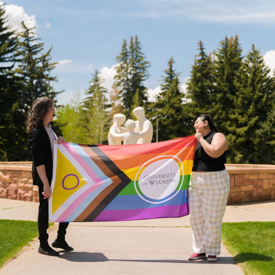 Two people holding flag in prexi. 