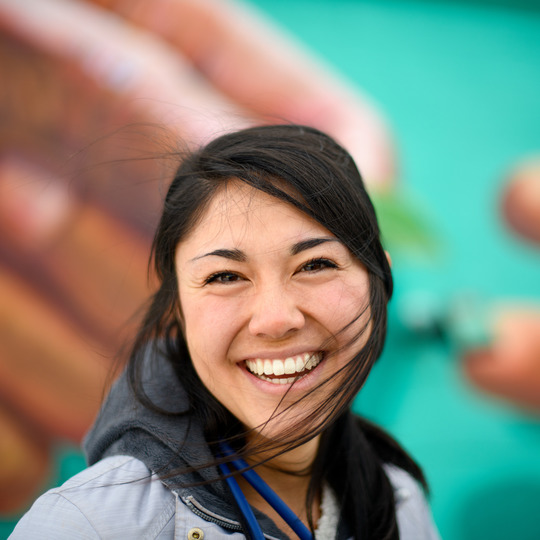 Person in front of mural. 