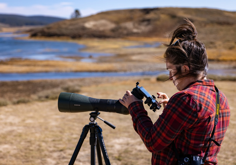 student with a large camera outside