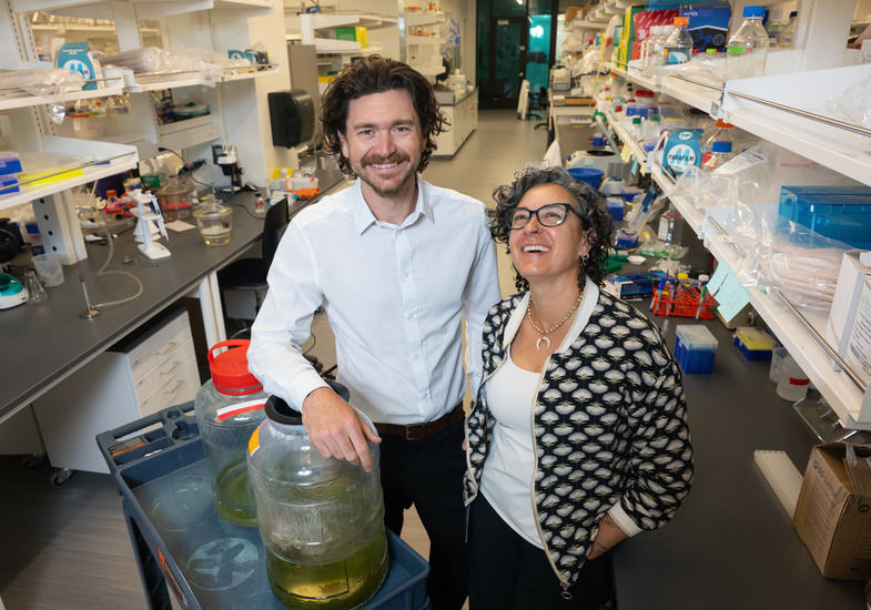 Two faculty members smile for a photo in a lab