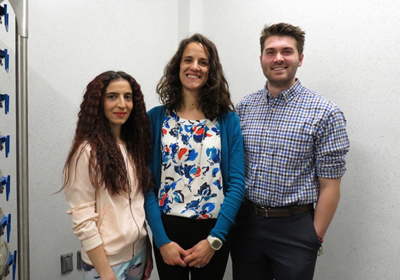 Three scientists smile for a photo