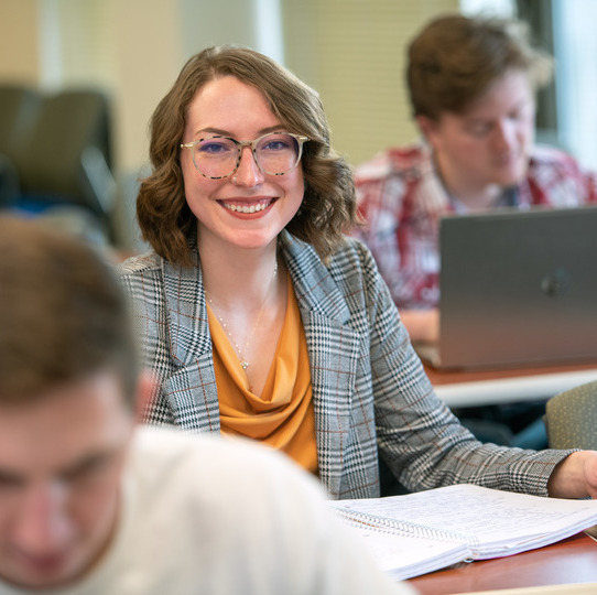 A student in class smiles at the camera