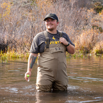 A student takes a sample of a river