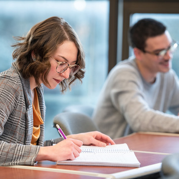 A new graduate student at the University of Wyoming takes notes during a class lecture at UW. 