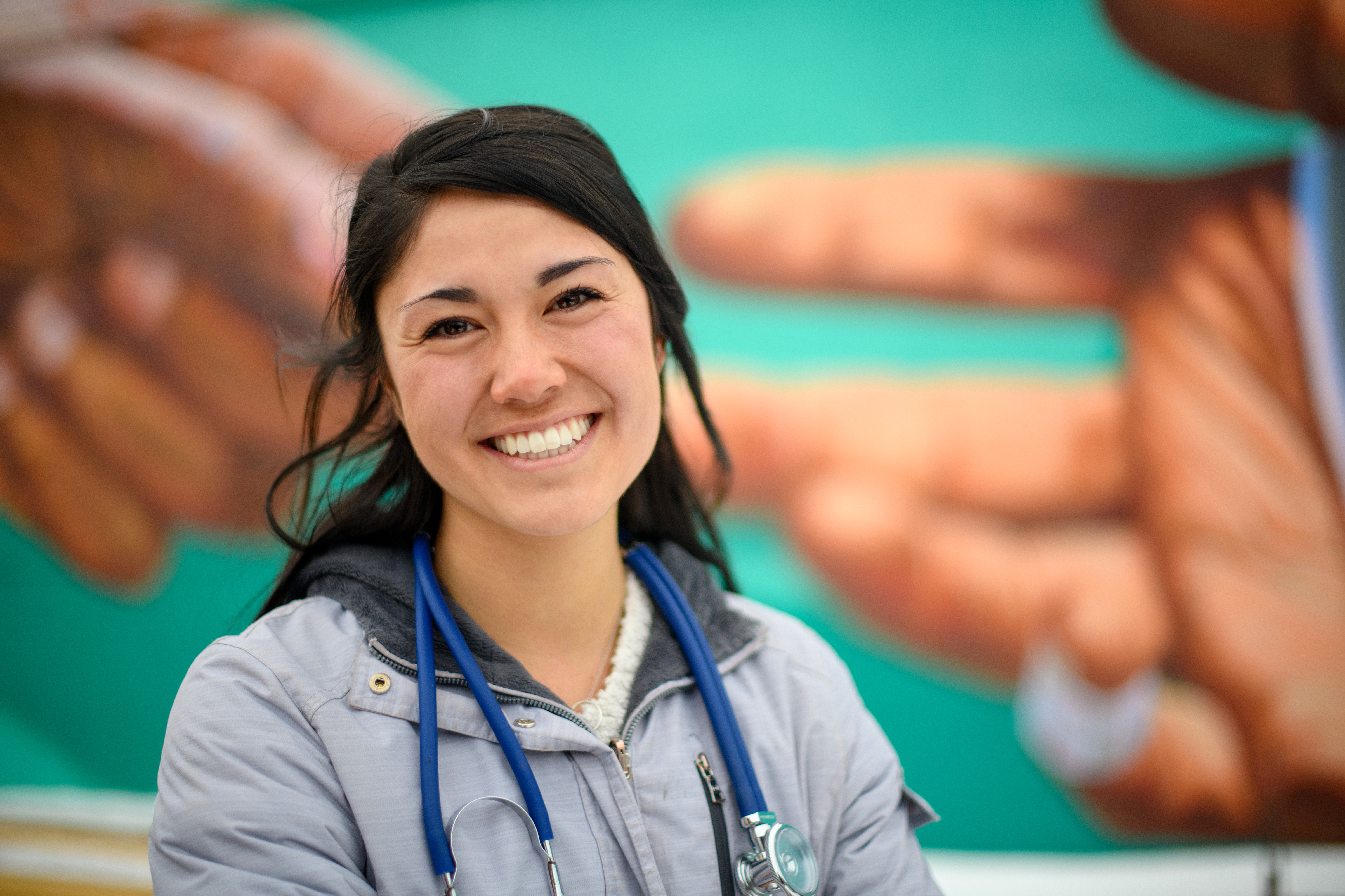 Graduate student in front of a mural