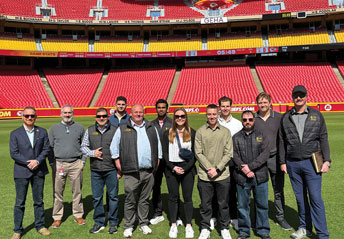 student and faculty on the field at the Kansas City Chiefs stadium