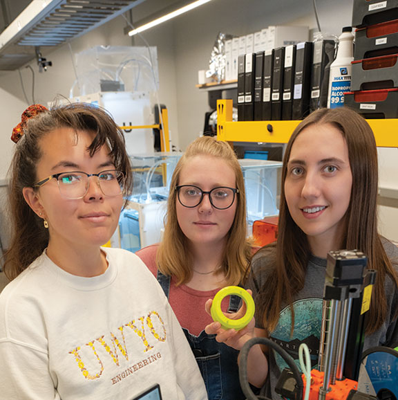 three females students holding 3D model in makerspace