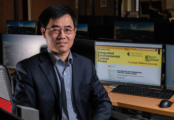 professor sitting in front of a computer in a computer lab