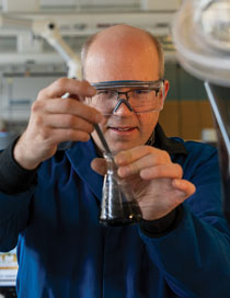 researcher holds a beaker of fluid in a lab
