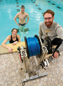 two mechanical engineering students and a swimmer worked in the pool with their resistance training equipment