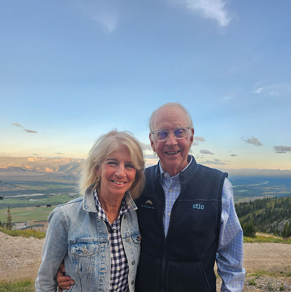 two people outside with mountains behind them