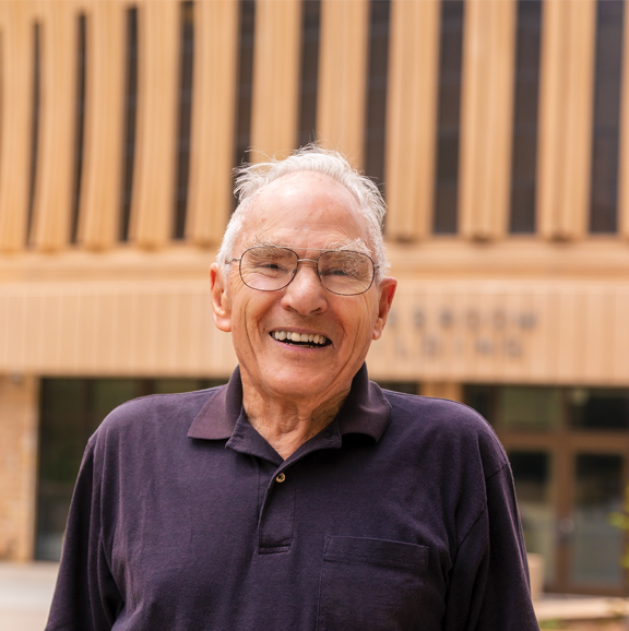 man posing in front of Classroom Building on UW Campus