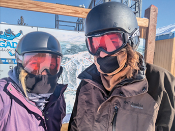 Two people in ski helmets and face masks