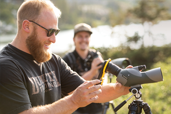 Professor and research assistant use spotting scopes in rural Wyoming