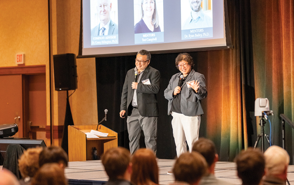 man and woman presenting on a stage in front of an audience
