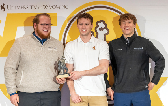 Three men holding an award at the 50K Competition