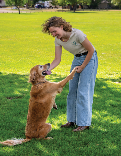 woman and dog play at a park