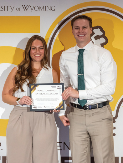 male and female student hold a certificate