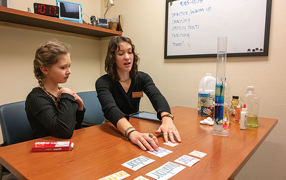 Female adult and young child work with flashcards at a table