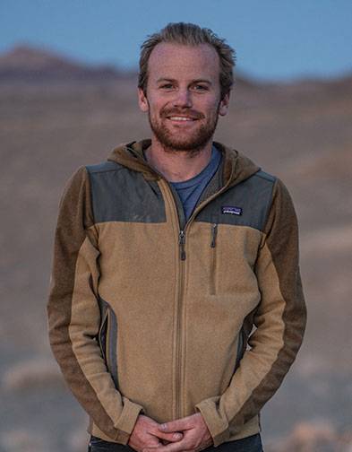 man standing outside in a rocky terrain