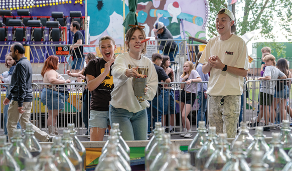 woman throwing ring at bottle at a carnival