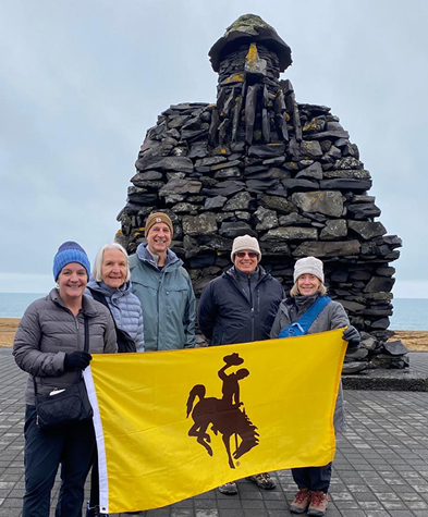 group holds UW flag in Iceland