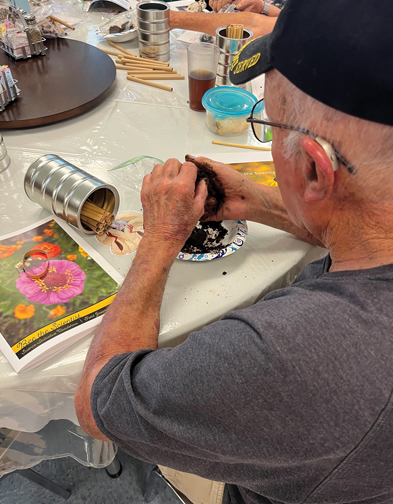 older man holding dirt in his hands