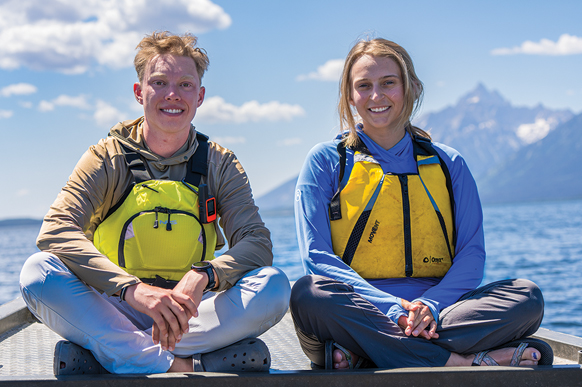 Male and female students on a watercraft on a lake