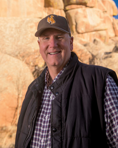 Man poses outside by large rocks in Vedauwoo