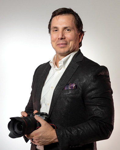 Man in a suit holds a camera