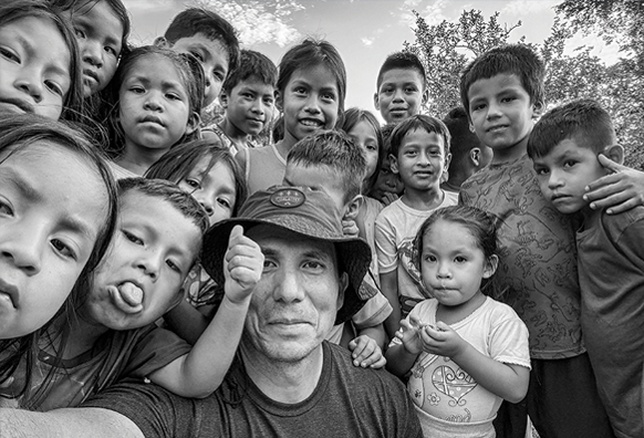 Man takes a selfie with group of young children in Peru