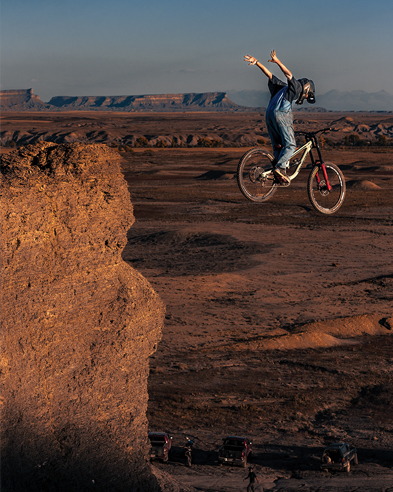 Mountain biker jumping off a cliff with arms spread