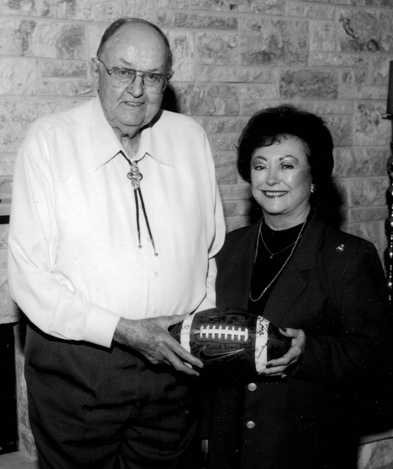 archive image of two older adults holding a football