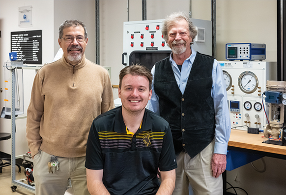 group of three men in a lab with equipment