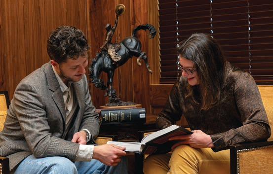 female professor and male student looking at a book