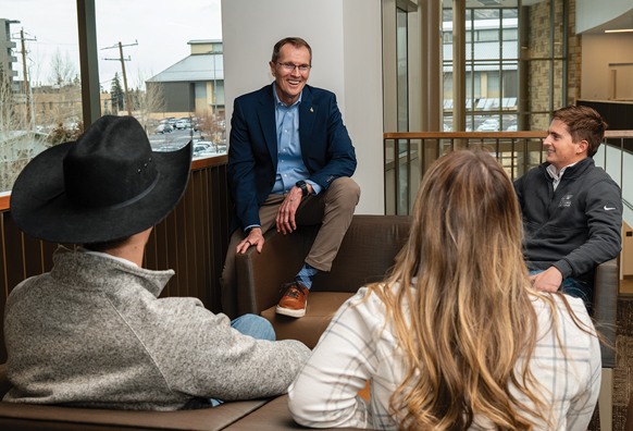 Male professor talks with a group of students