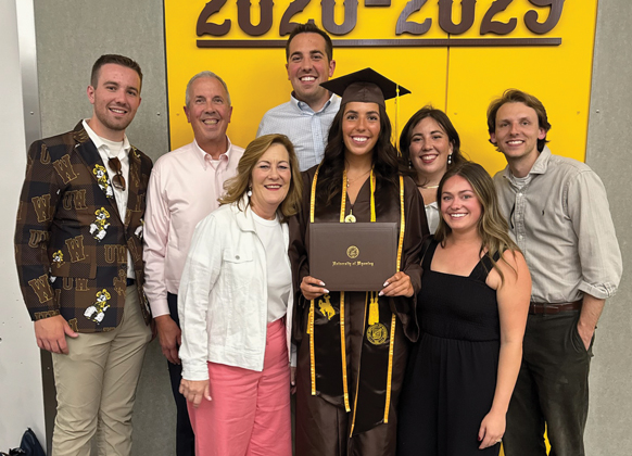 Large family poses in the Arena Auditorium during commencement