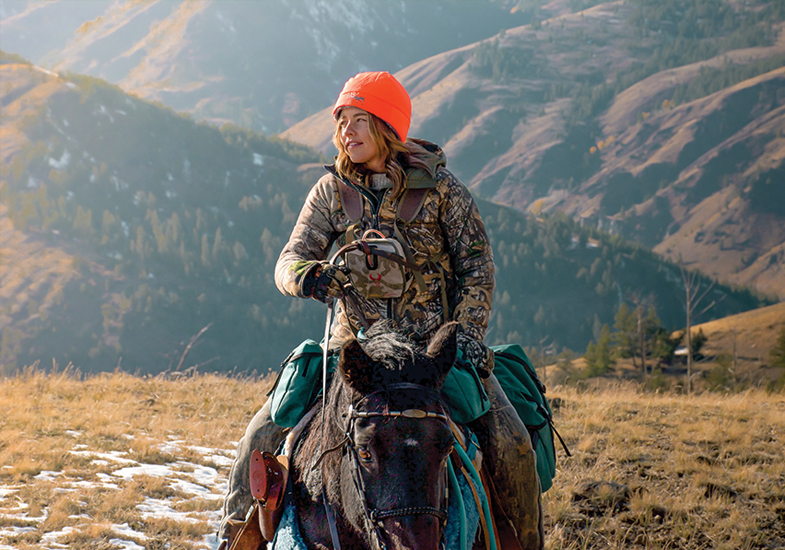 person riding a horse in the mountains