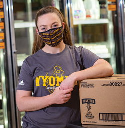 person in facemask leaning on a box