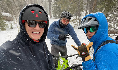 people in the snow with bicycles