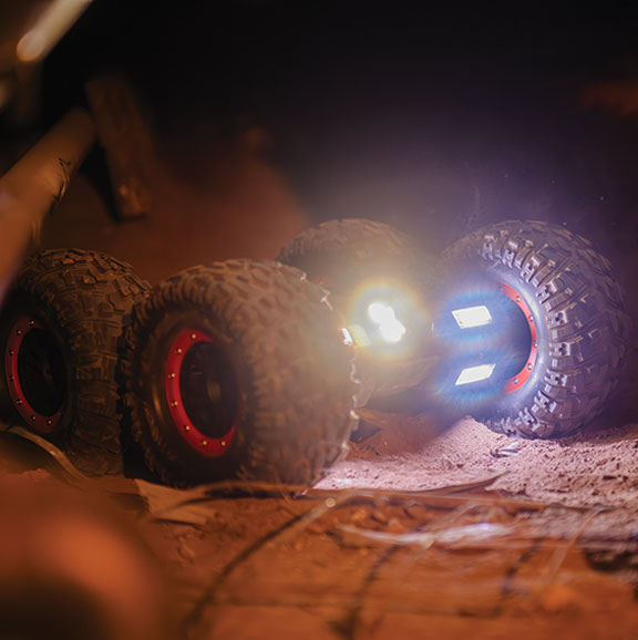 four wheeled robot vehicle with lights shining from it