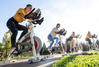 people on exercise bikes outside