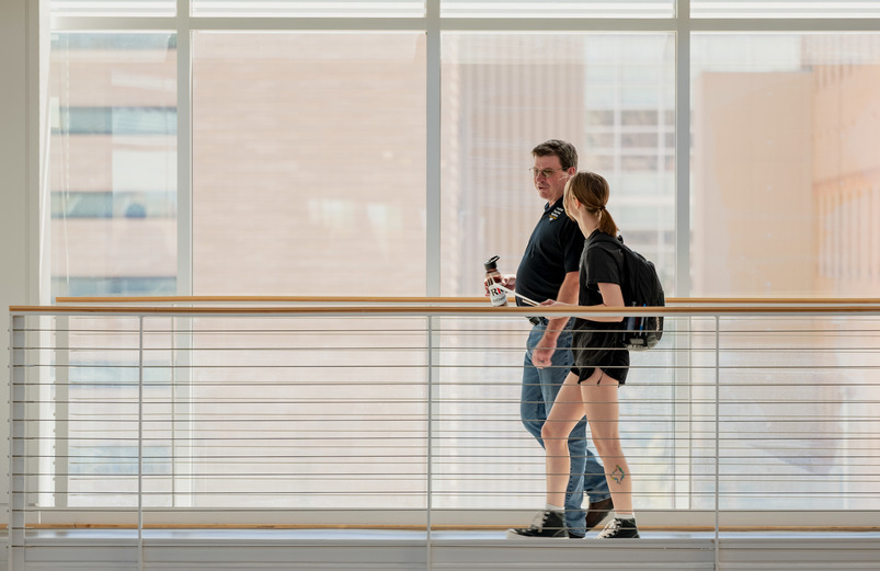 Two people walking and talking on UW Campus