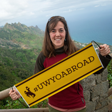 Student holding a #UWYOAbroad Banner