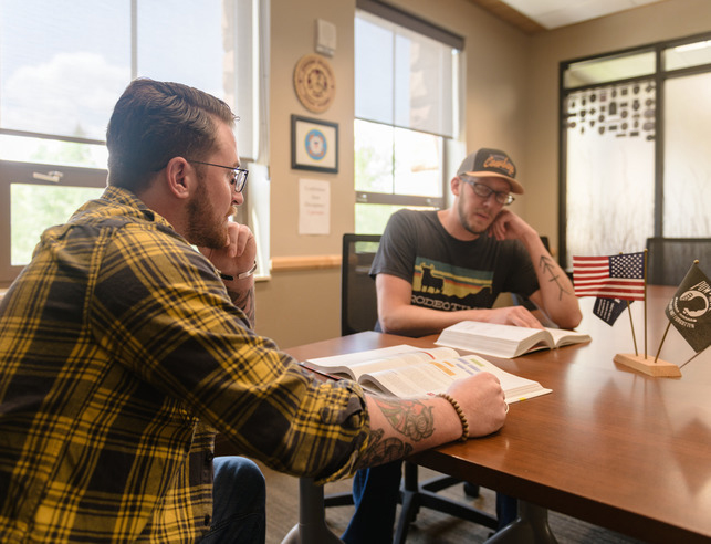 Two veterans sitting at a table talking