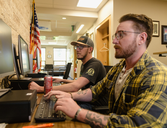 Two veterans working at computers