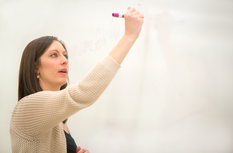 Teacher writing on a whiteboard