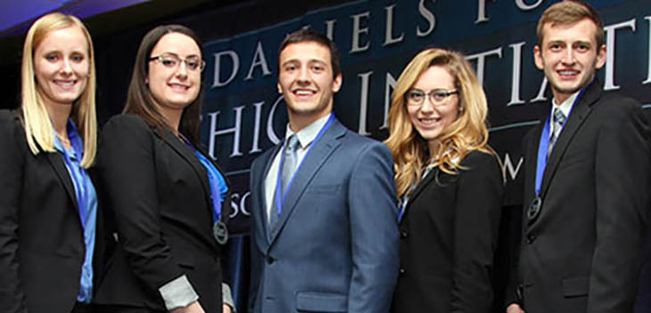 Five professionals posing for a picture.