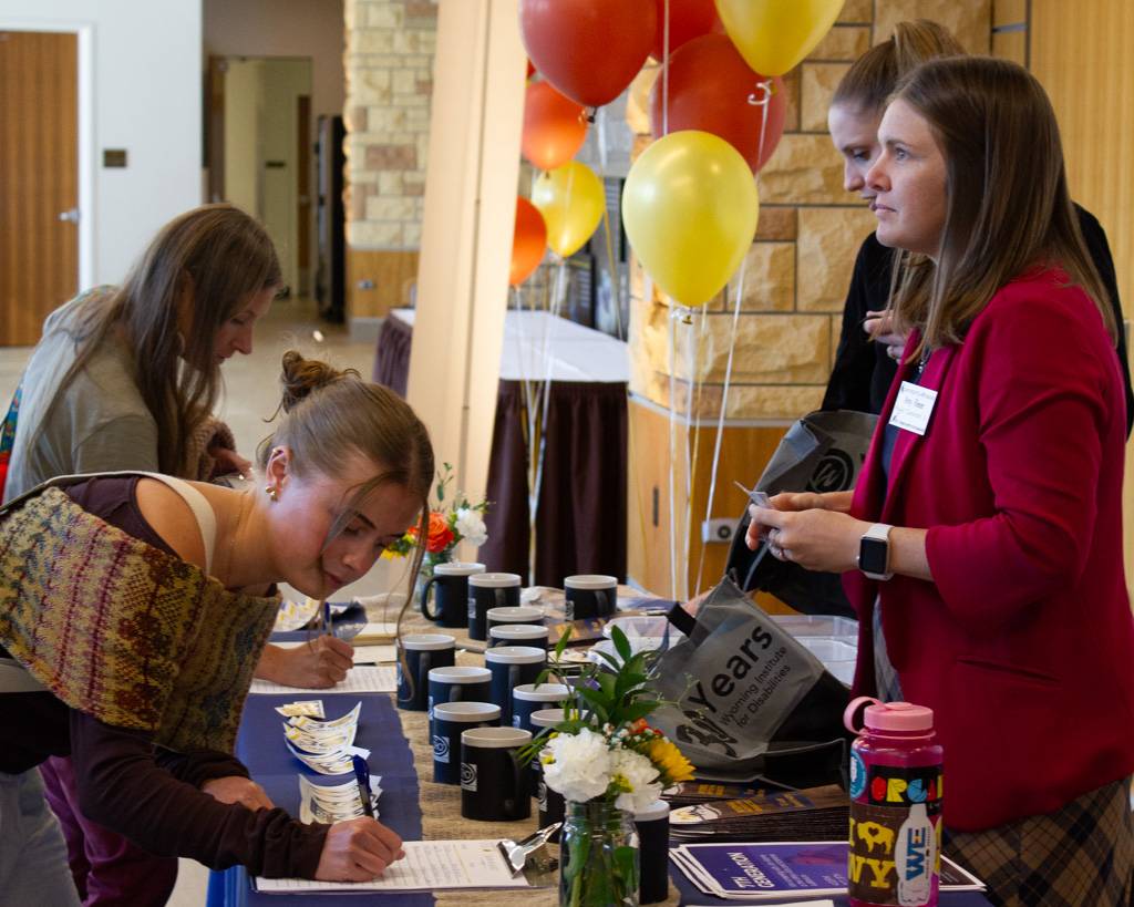 Two individuals registering for the event with two WIND employees.